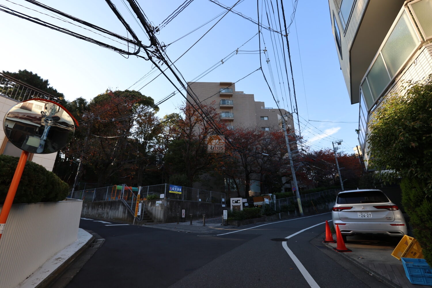 山王ガーデンハイツは、平成1年築、14階建てのマンションです。街区入口のカーブを進むにつれて建物が少しずつ姿を見せ、周囲の静けさが自然に整っていきます。視界が開けた道路と歩道の取り合いがスムーズで、生活動線としての安心感が保たれています。高台の位置が街並みと樹木を層のように重ね、帰宅時に穏やかな空気へ切り替わっていく流れを日々感じています。