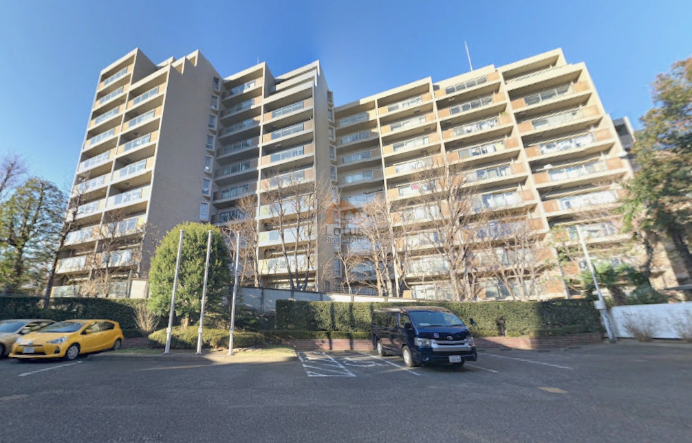 整然と並ぶバルコニーが南面に向かって開かれ、光を受けて建物全体が明るい印象を与えます。手前には平置き駐車場があり、ゆとりある敷地設計が伺えます。高台の立地にふさわしく、見上げると空の広がりが強調され、開放的な景観が感じられます。山王ガーデンハイツは、平成1年築、14階建てのマンションです。