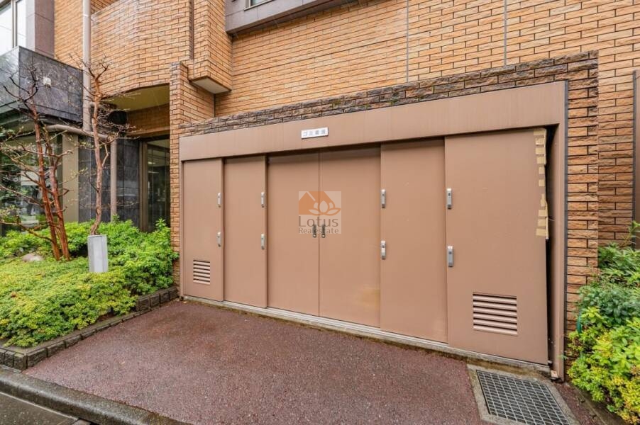 レクセルマンション笹塚ゴミ置場｜ゴミ置場は、建物外壁と同系色の扉で、専用スペースとして建物に隣接して配置されています。