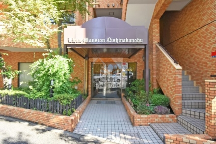 ライオンズマンション西中延エントランス１｜エントランスは植栽に囲まれたアプローチが整備され、屋根付きの庇が設けられています。