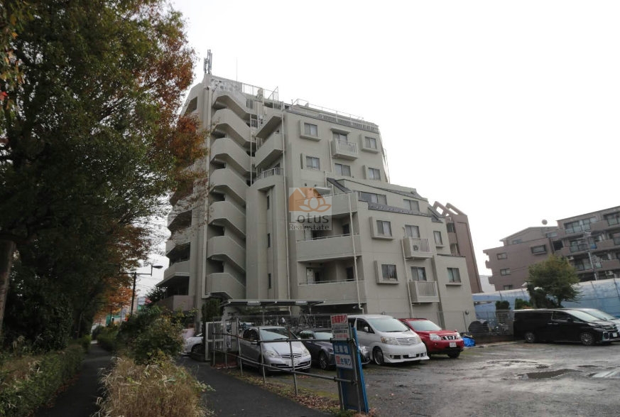 環八通りに面した外観が、街の動線に自然と溶け込んでいます。淡いトーンの外壁は落ち着いた質感で、周囲の緑との対比が柔らかく映ります。住棟の水平ラインが穏やかに重なり、日常を支える住まいとしての安心感がにじむ構成です。