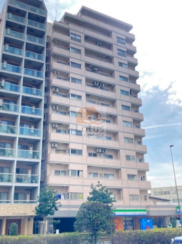 ィルズ大森町の外観：白系タイル貼りの13階建てマンションで、バルコニーが整然と並ぶ垂直ラインが印象的。1階にはファミリーマートが入居し、生活利便性が高い。ヴィルズ大森町は、昭和62年築、13階建てのマンションです。