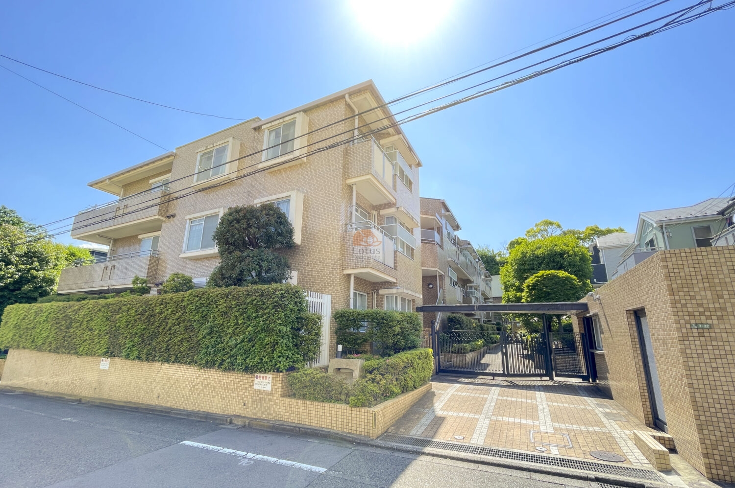 低層3階建のラシーヌ砧は、ベージュ系タイル張りの外壁に整えられ、バルコニーにはガラス手すりが設置されていました。道路沿いには高さのある生垣が整備され、建物正面には車寄せを兼ねたゲートアプローチが設けられていました。ラシーヌ砧は、昭和61年築、3階建てのマンションです。