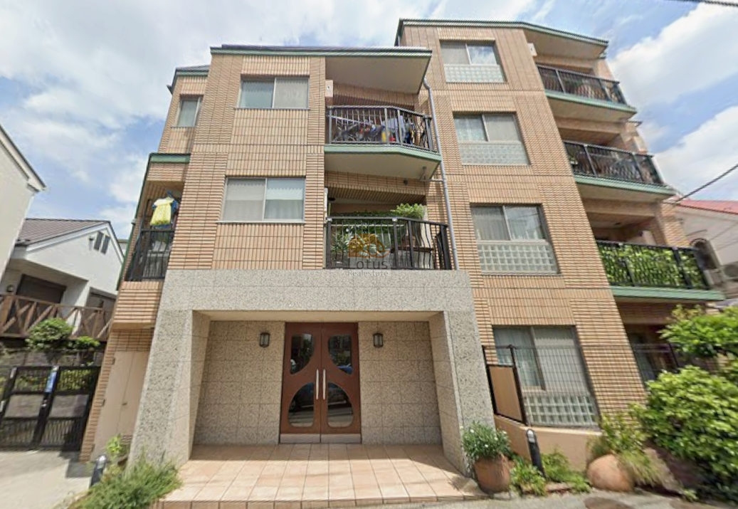 駅徒歩4分の立地にふさわしく、落ち着いた住宅街の中で端正なタイル貼りの外観が整然とした印象をつくります。低層4階建の佇まいは周囲の戸建と高さをそろえ、街並みに溶け込む穏やかなスケール感です。オートロックや宅配ボックスの設備を備え、ペット飼育可という柔軟さも日常のゆとりにつながる設計です。