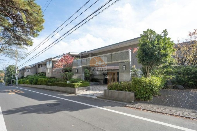 第一種低層住居専用地域に建つ低層レジデンスの外観で、植栽とセットバックした配置により通行音が抑えられた前面環境といえます。