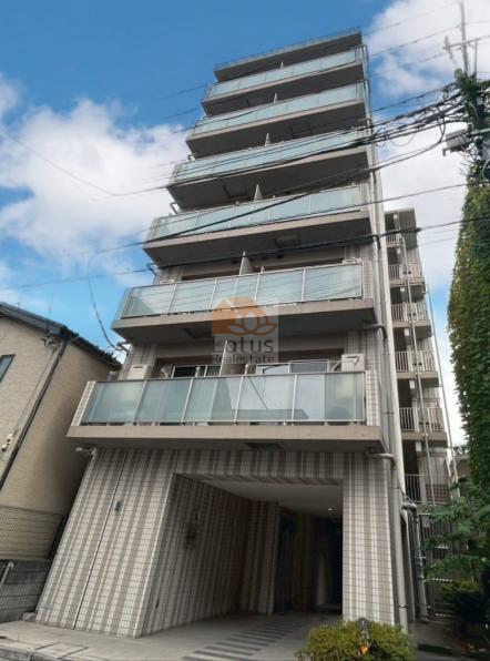 直線的なフォルムが印象に残ります。RC造7階建・総戸数18戸というコンパクトな規模感で、通りからの距離がほどよく保たれ、鶯谷駅徒歩6分という立地ながら、車音がやややわらいで聞こえる配置です。ガラス手すりのバルコニーが連なり、光を反射して表情が変わる外観は、派手さよりも落ち着きを重視した住まいの佇まいといえます。